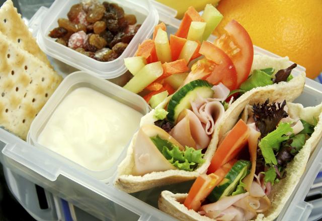 健康的学校午餐，以皮塔饼三明治、蔬菜和葡萄干为特色.